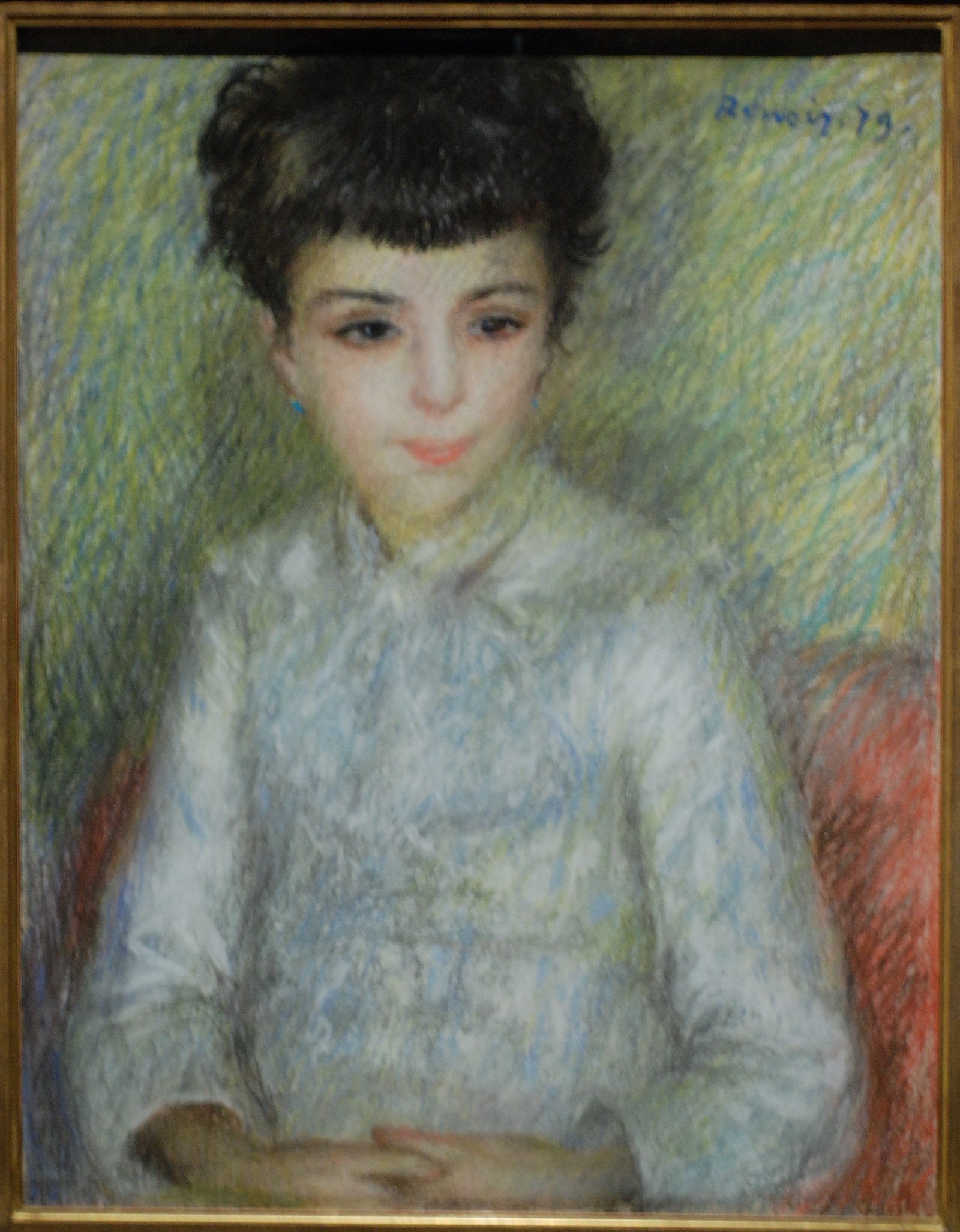 Portrait of young brunette girl, sitting with hands crossed