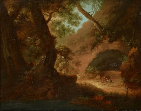 Wolves in the forest in front of a cave